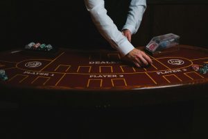 Bàn baccarat trực tiếp với dealer đang chia bài trong không gian casino hiện đại